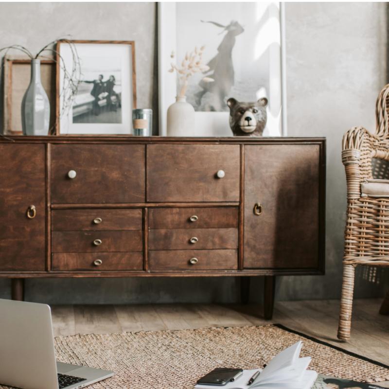 Leaning framed wall art styled on a mid-century sideboard with natural decor elements, showing how to display art without hanging it on the wall.